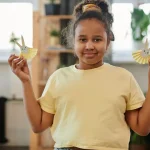Child holding two paper bunny crafts