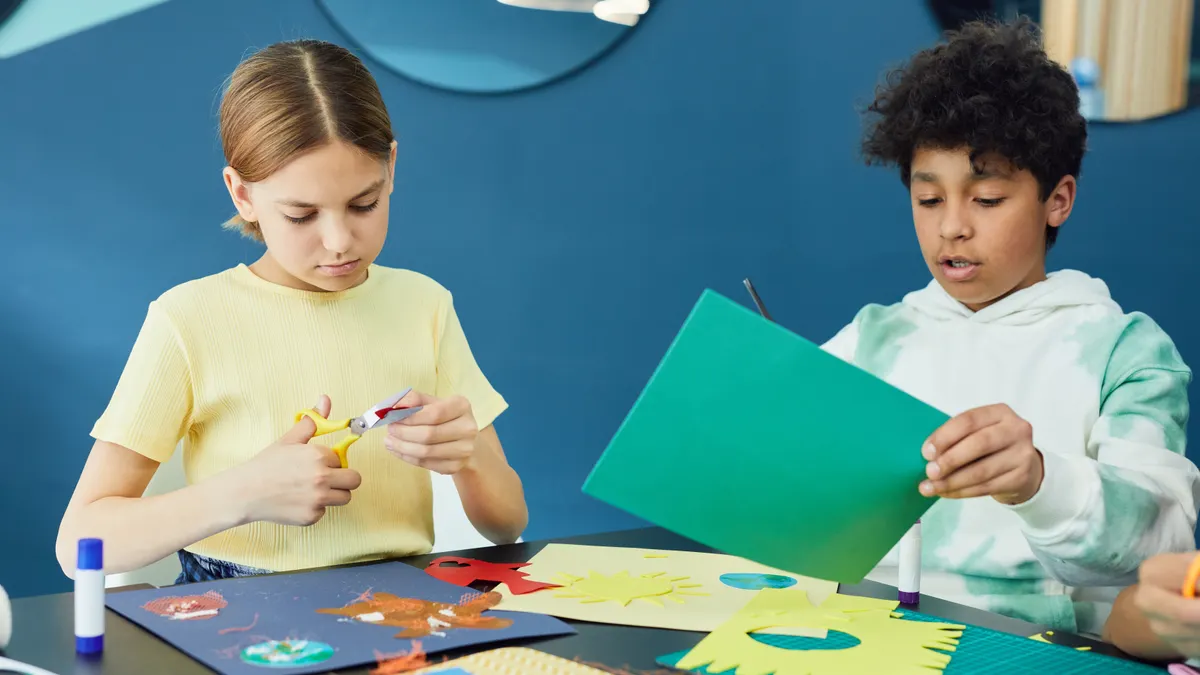 Children cutting and assembling colorful paper crafts