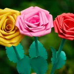 Hand holding colorful paper rose flowers