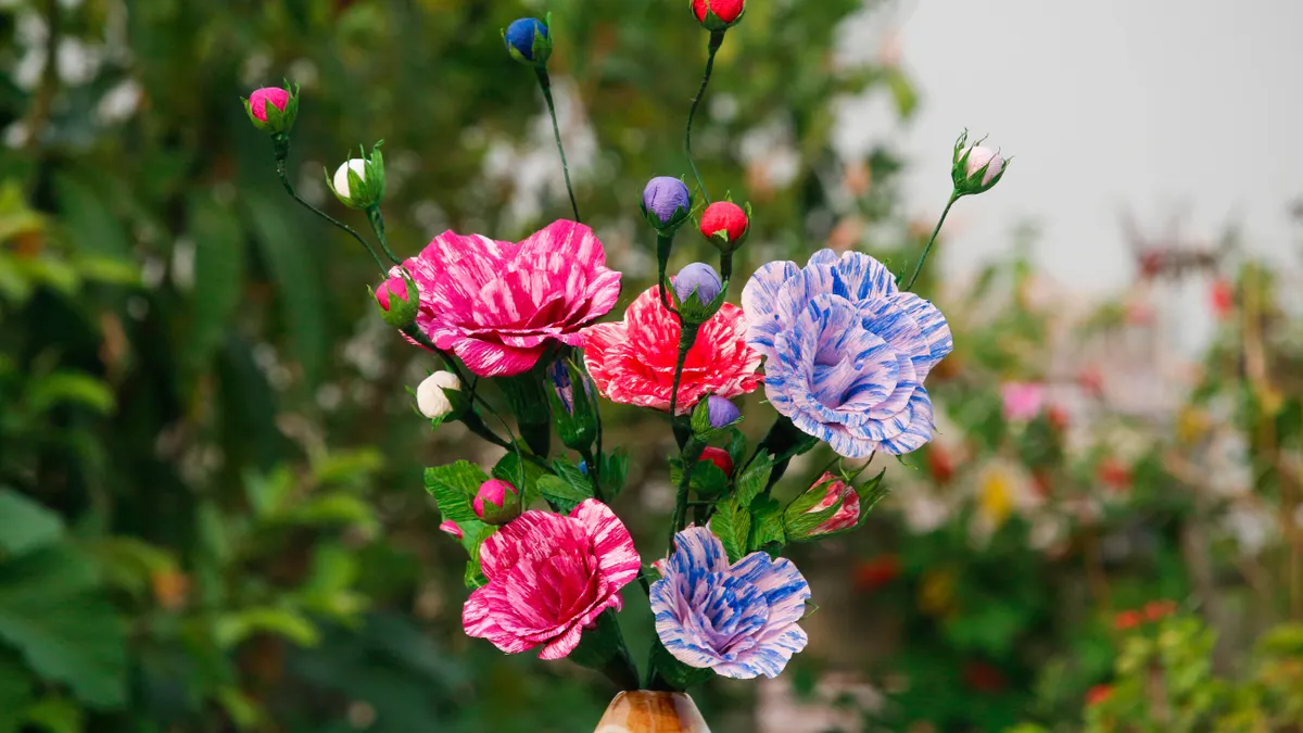 Hand holding a bouquet of crepe paper flowers