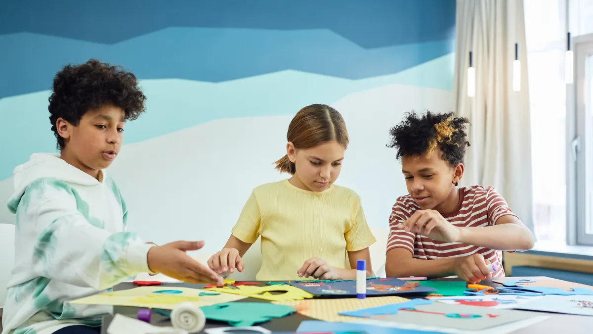 Children making paper crafts together at a table