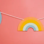 Rainbow paper garland on a pink wall