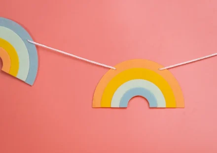 Rainbow paper garland on a pink wall