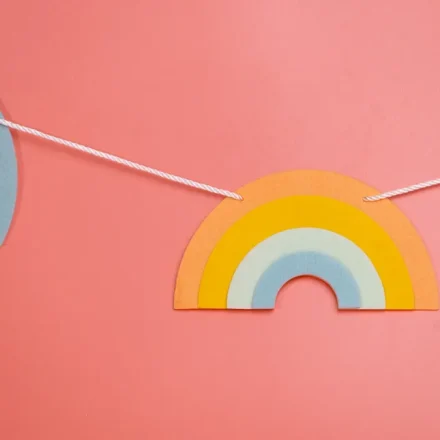 Rainbow paper garland on a pink wall