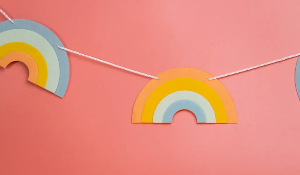 Rainbow paper garland on a pink wall
